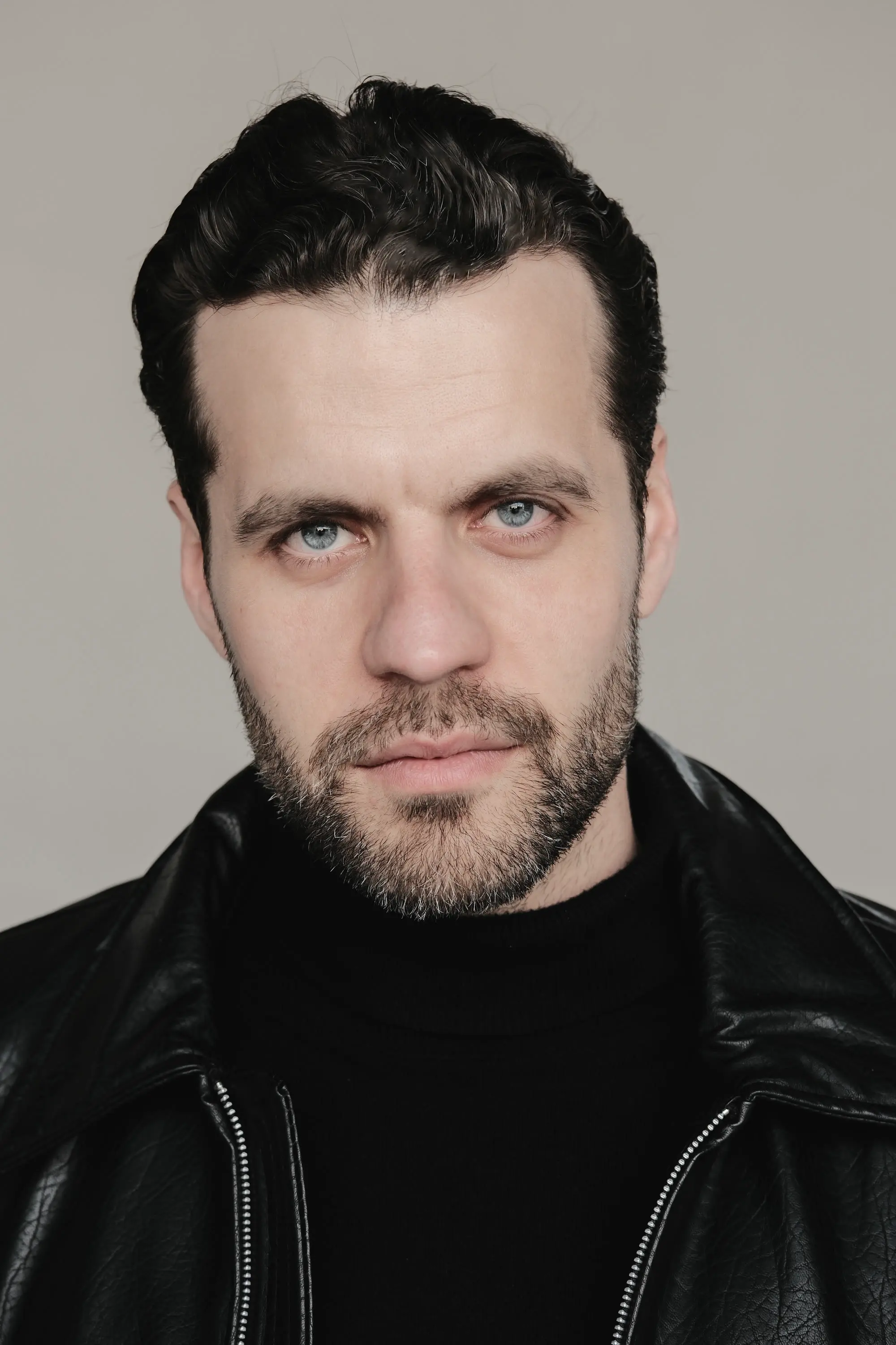 Retrato de Jacobo Abellás con chaqueta de cuero sobre fondo claro